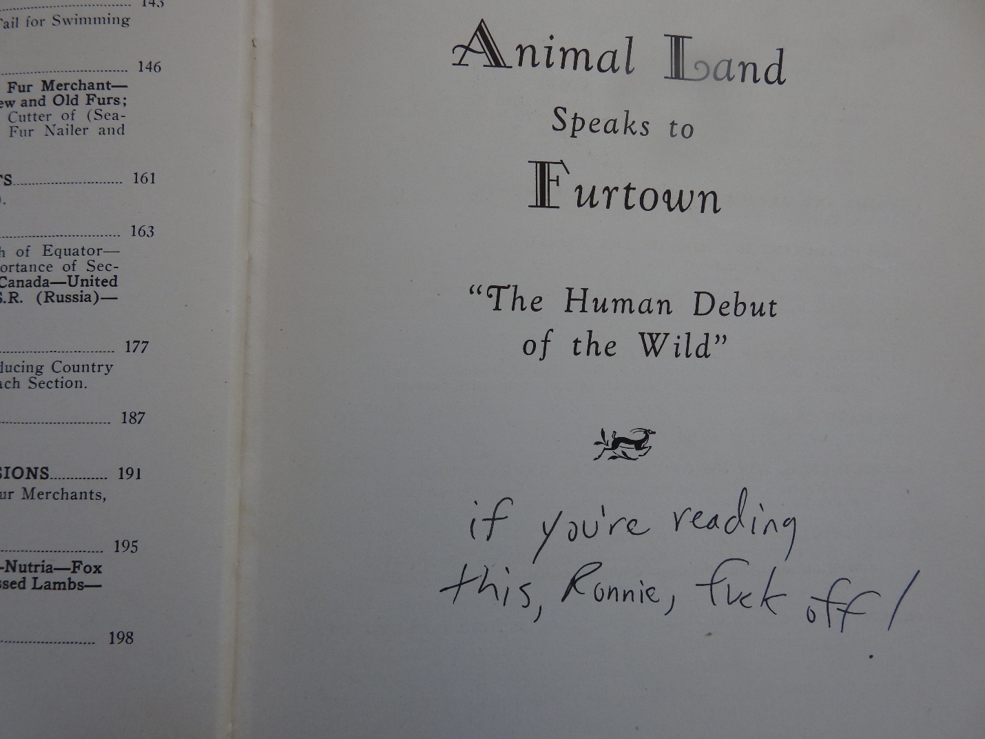 Photograph of the title page of the book 'Animal Land Speaks to Furtown', subtitled 'The Human Debut of the Wild'. A handwritten note underneath the subtitle says, 'if you're reading this, Ronnie, fuck off!'